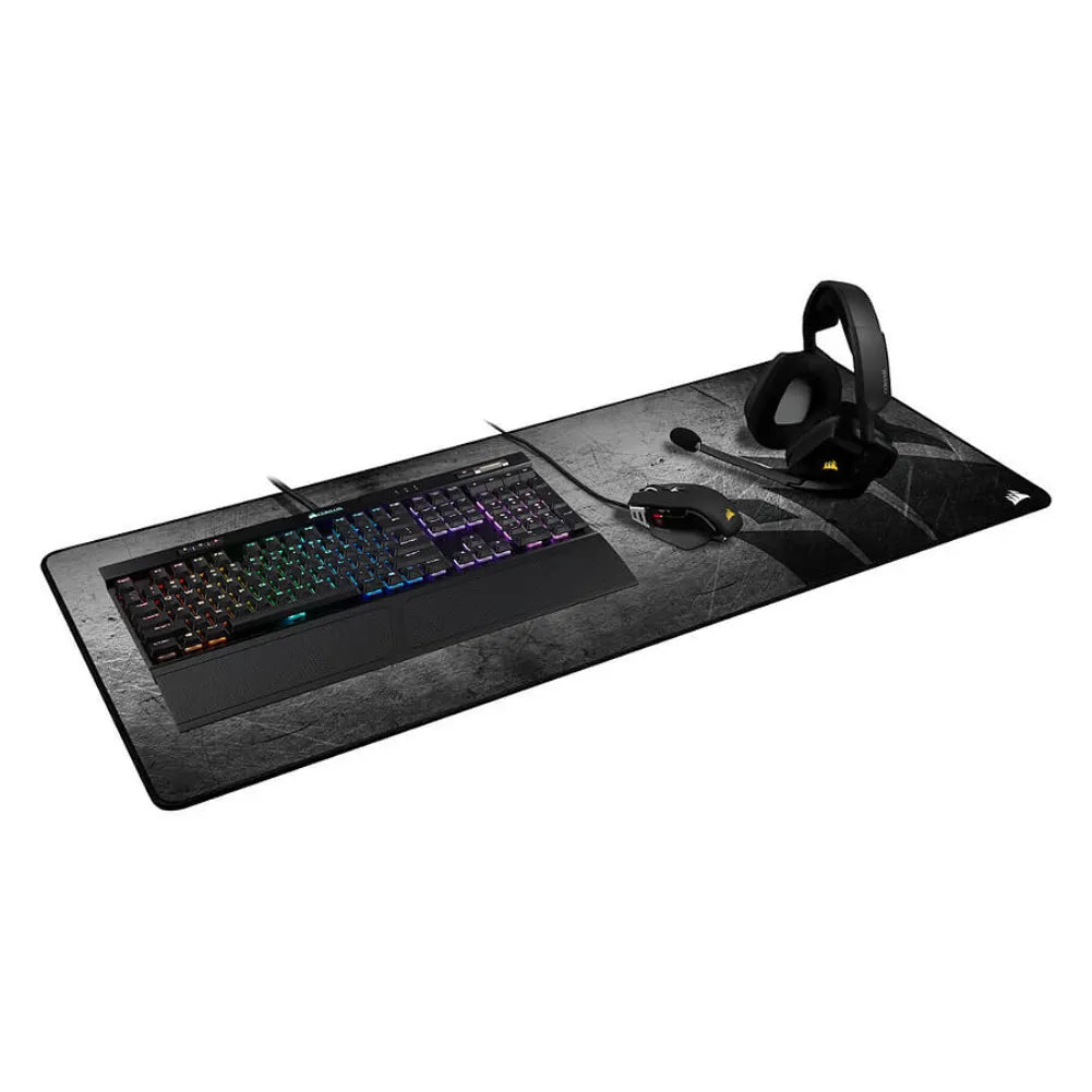 Corsair MM350 Pro Gris XXL gaming mouse pad with RGB keyboard and headset setup.