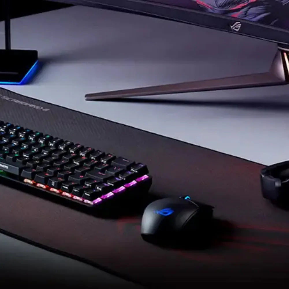 ROG Scabbard II XXL gaming mouse pad with RGB keyboard and gaming mouse on a sleek desk setup.