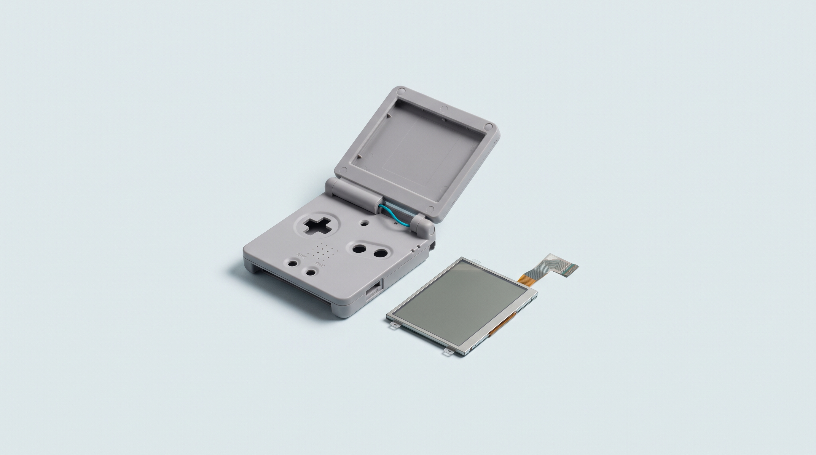 Coque de console à clapet ouverte et dalle d'écran LCD nue posée à côté, avec sa nappe