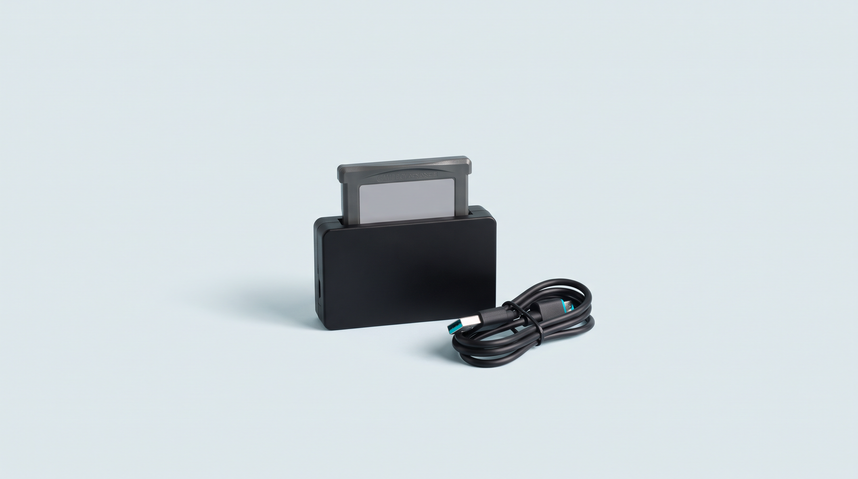 Lecteur de cartouches noir avec une cartouche insérée et un câble USB enroulé à côté