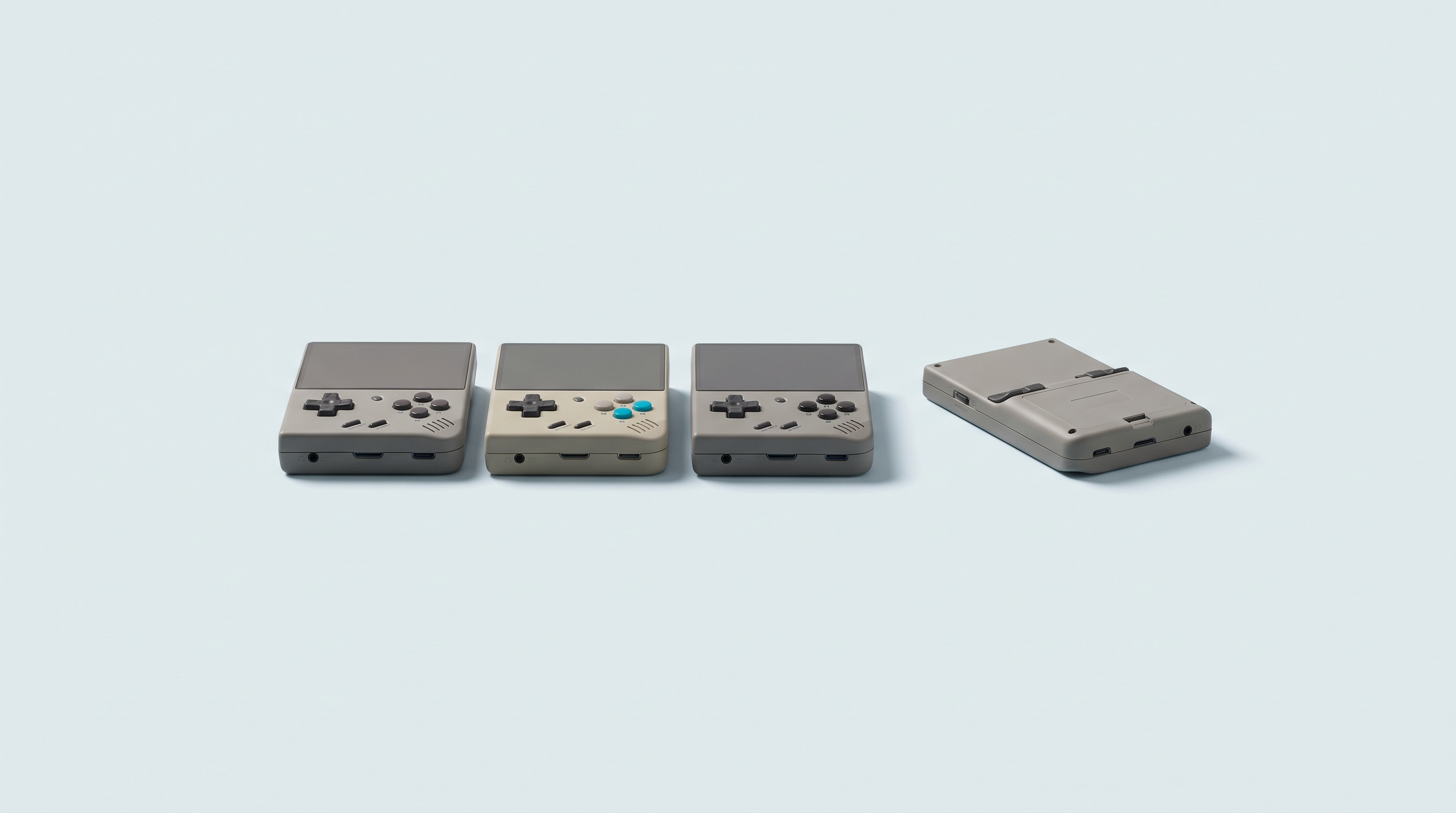 Trois consoles portables rétro groupées, une quatrième retournée et mise à l'écart