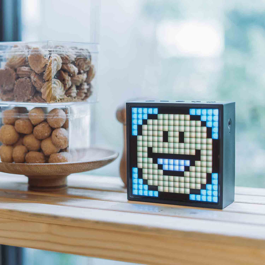 Divoom Timebox-Evo sur un meuble, émoji à l'écran