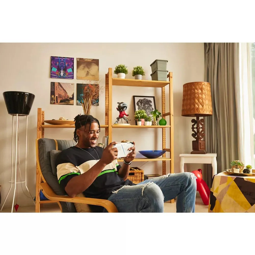 Young man sitting in a modern chair, joyfully gaming with a controller in a cozy living room setting.