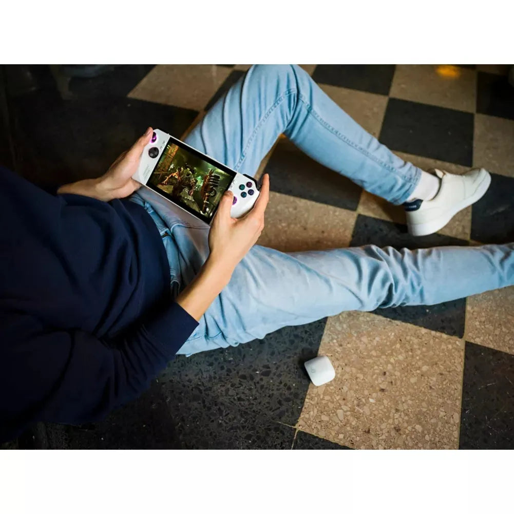 Person playing a portable gaming console on the floor, showcasing the immersive gaming experience.