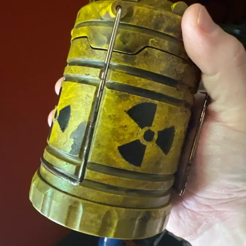 Lanterne rétractable tenue en main, pictogramme de radioactivité imprimé sur le corps