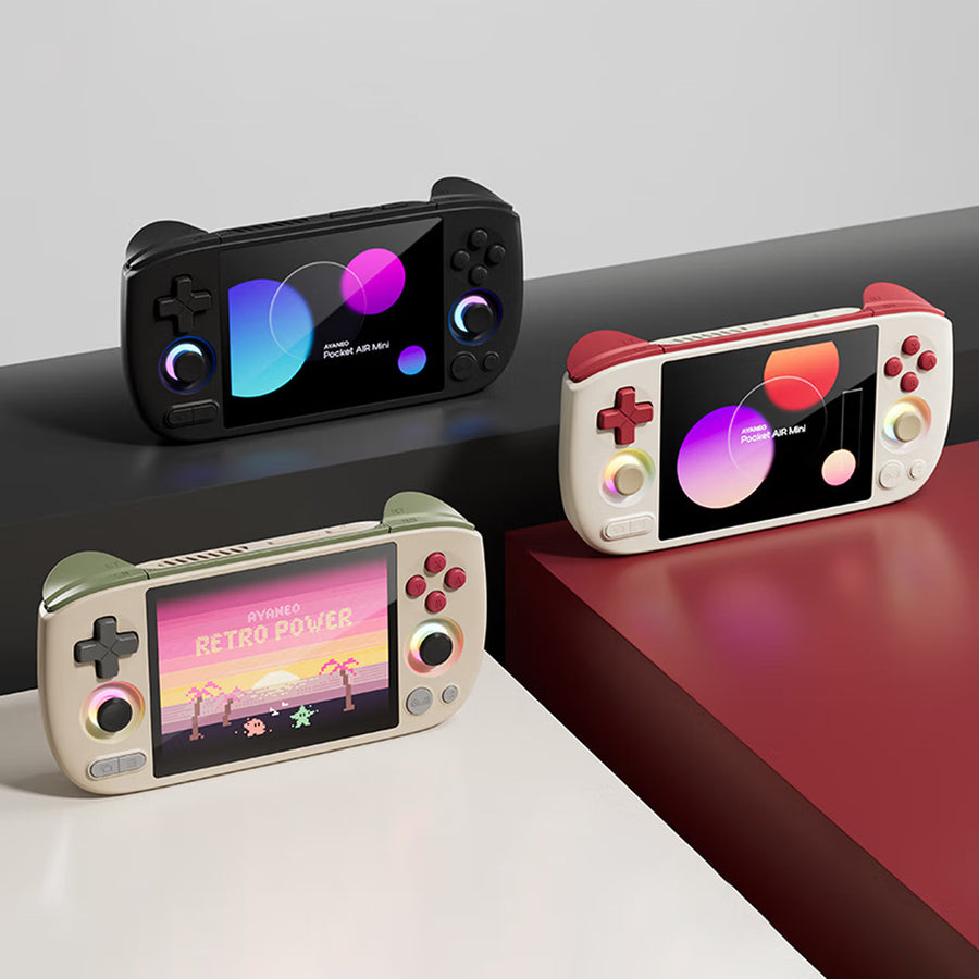 Les trois coloris de la Pocket AIR Mini réunis — Noir, Blanc et Retro Power — posés sur un plan blanc et rouge