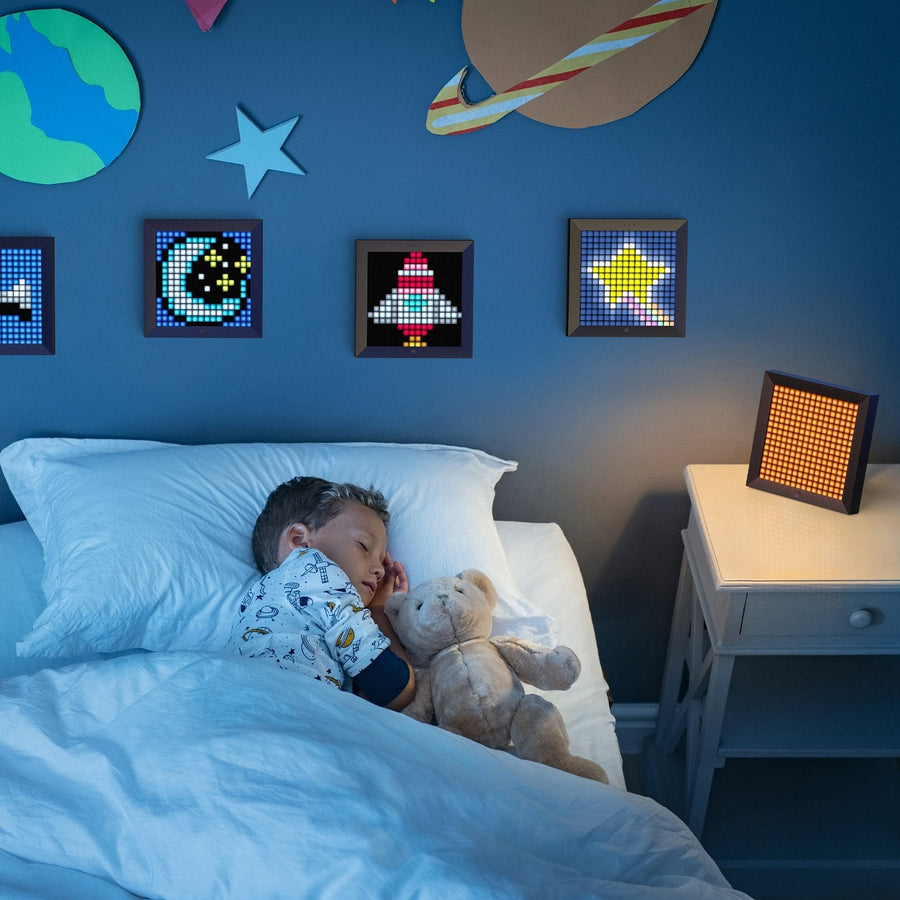 Divoom Pixoo sur une table de chevet dans une chambre d'enfant