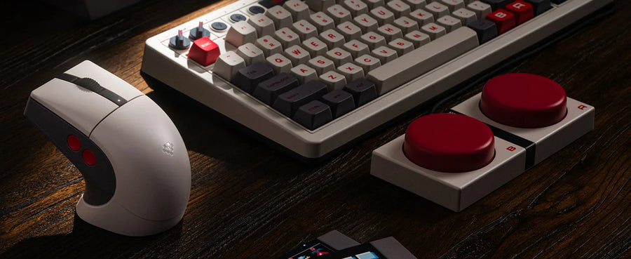 8BitDo Retro R8 N Edition mouse on a desk next to a retro mechanical keyboard