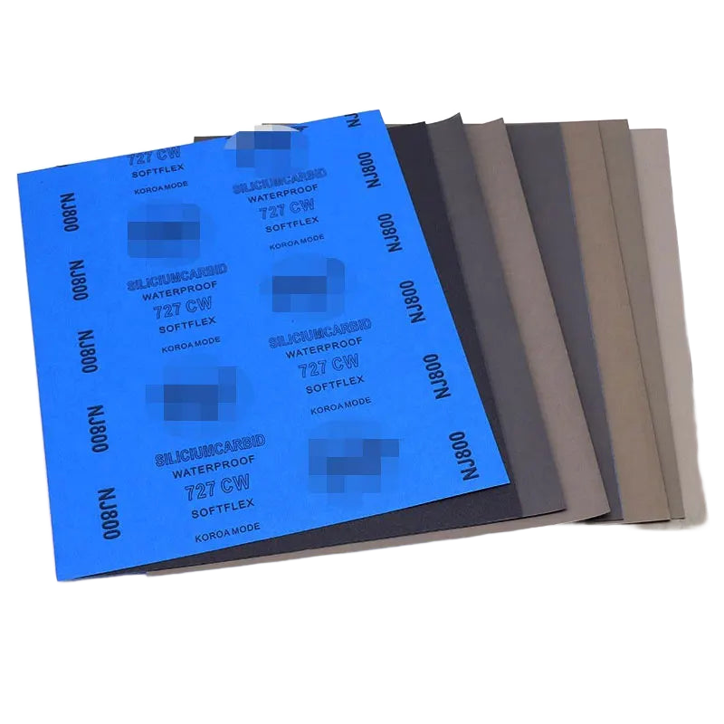 Deux feuilles de papier abrasif à l'eau superposées, face abrasive et dos imprimé visibles